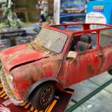 Ci spostiamo nel secondo locale, dove Annamaria ci mostra il modellino di una Fiat 500 rossa completa di ruggine, fango, ragnatele, erbacce, graffi e ammaccature